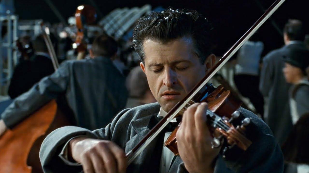 Scene the film "Titanic", in which the band plays "Nearer, My God to Thee" as passengers board lifeboats behind while the ship sinks. Closeup of one violinist playing with great focus.