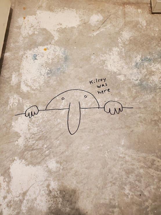 The classic "Kilroy Was Here" meme, featuring a cartoon man with a large nose peering over a wall, and the text "Kilroy was here".