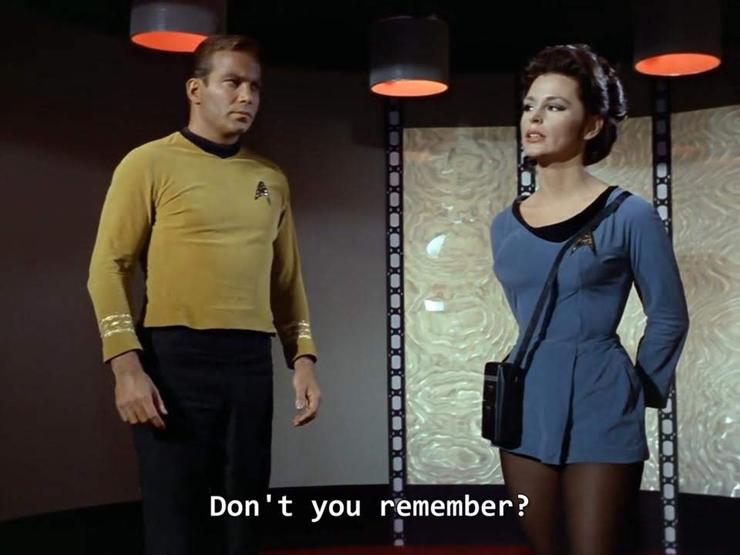 TOS scene. We're in the ol' transporter room with the ceiling circles and backdrop panels. Kirk is standing on the platform. He's turned towards and looking at a female officer to his left with some anxious energy it seems. She is looking straight forward, as if to purposefully not regard him. Closed caption reads, "Don't you remember?"
"The science lab Christmas party. Yes, I remember."