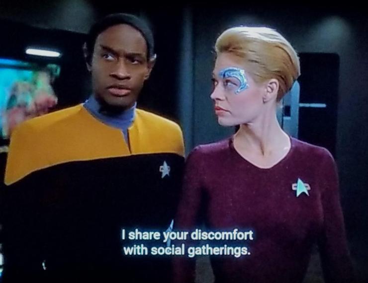 Star Trek Voyager scene. We've got Tuvok standing next to Seven of Nine (Tertiary Adjunct of Unimatrix 01). She's looking and him, and he's doing a smouldering, eyebrow popping look off into the distance thing. Closed caption reads, "I share your discomfort with social gatherings."