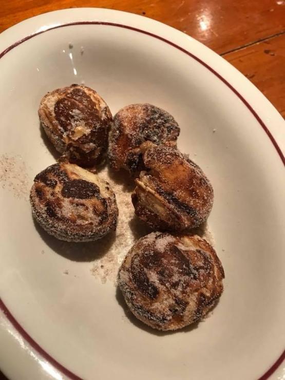 five spherical pancakes about the size of a golf ball covered in cinnamon and sugar